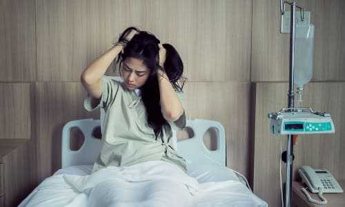 Женщина в больнице испітівает головную боль