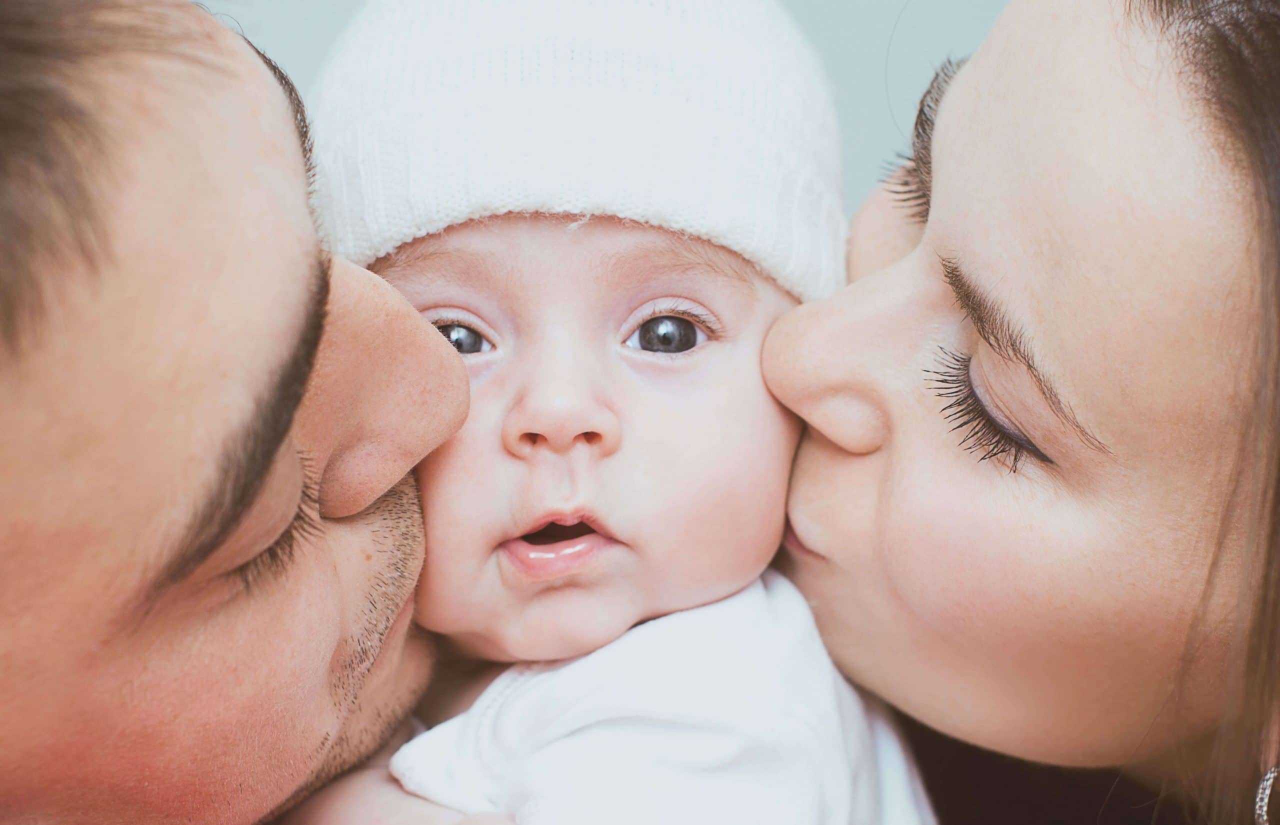 Мама и папа целуют ребенка