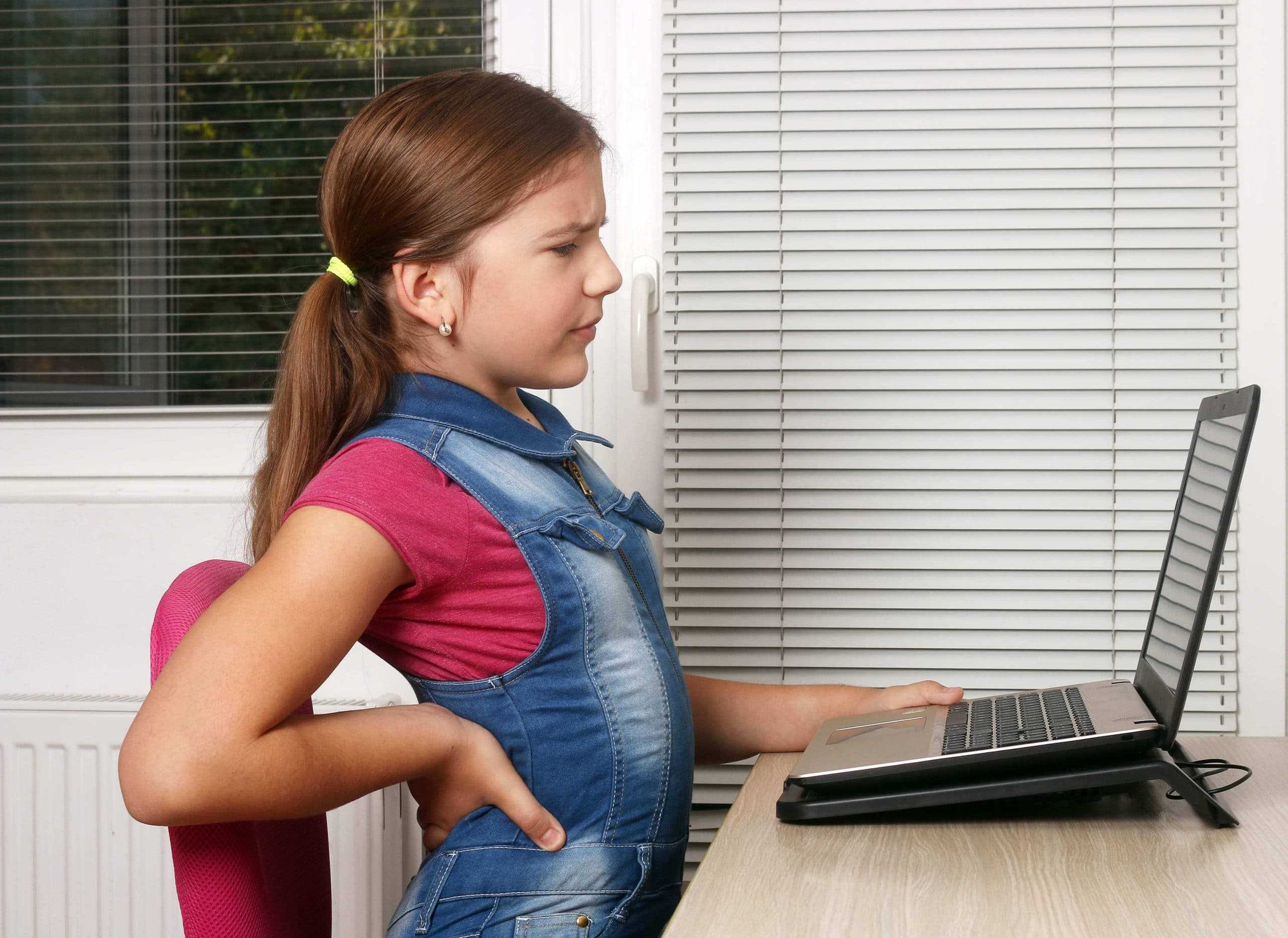 Девочка неправильно сидит за компьютером из-за чего боль в спине
