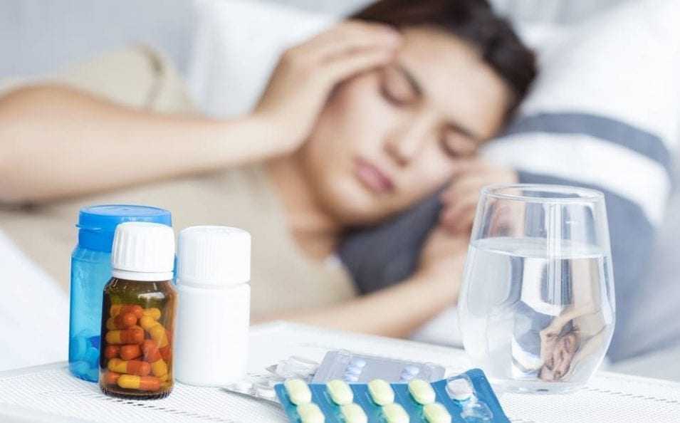 Приступ мигрени у женщины в постели